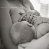 In a series of images that capture the connection and bliss between breastfeeding mother and child, this newborn's hands are intertwined with his mother's.