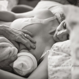 This new mother is learning how to breastfeed by hands that are much more experienced than her own.