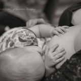 In a series of images that capture the connection and bliss between breastfeeding mother and child, this baby hugs her mother's breast.